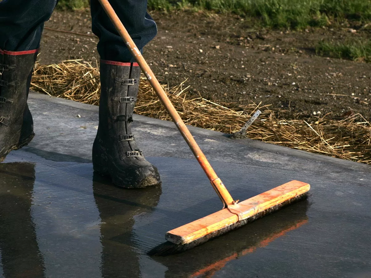 a person sweeping concrete